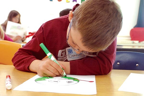 Donovin Henken works on a poster celebrating Earth Day during last Friday's Arlee Free Three program. The day's projects revolved around Earth Day.