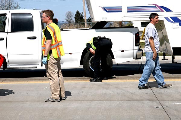 Police work to spray paint the area where the trucks wheels ended up after the incident. A man was dragged between the camper and truck when the brakes went out during an inspection on Hwy 35.