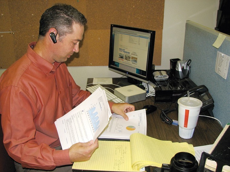 Columbia Basin Herald Manager of Internet Business Development, Kody Johnson looks through paperwork Thursday in his Moses Lake office.