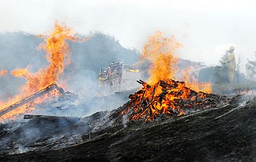 <p>Firefighters work to put out a slash pile at a grass fire south of Kalispell Wednesday. Four fire departments responded to combat the fire that covered several acres near Ashley Meadows Lane before it was contained. (Aaric Bryan/Daily Inter Lake)</p>