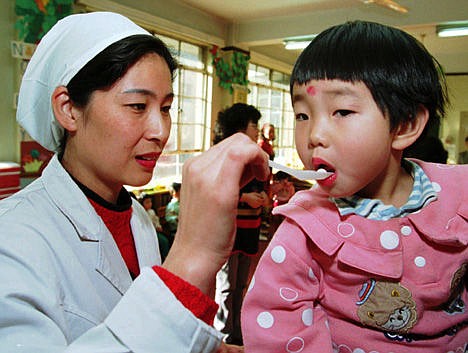 &lt;p&gt;Dr. Lai Nansha uses a spoon to administer a polio vaccination pill to a child at a kindergarten in Beijing, Dec. 6, 1995.&lt;/p&gt;