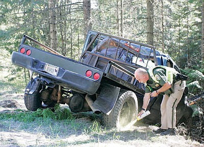 <p>MHP Trooper Bryce Ford at the scene of a single vehicle accident involving a blue and black 2002 4-door Dodge pickup at Highway 2 and Yaak Hill April 18, 2016.</p>