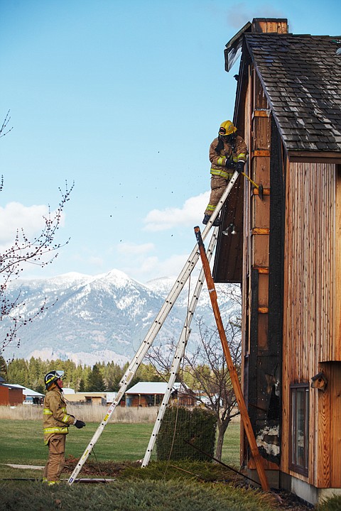 <p>Patrick Cote/Daily Inter Lake Creston firefighters remove siding to uncover hot spots at a chimney fire on east Evergreen Tuesday afternoon. Tuesday, April 17, 2012 in Kalispell, Montana.</p>
