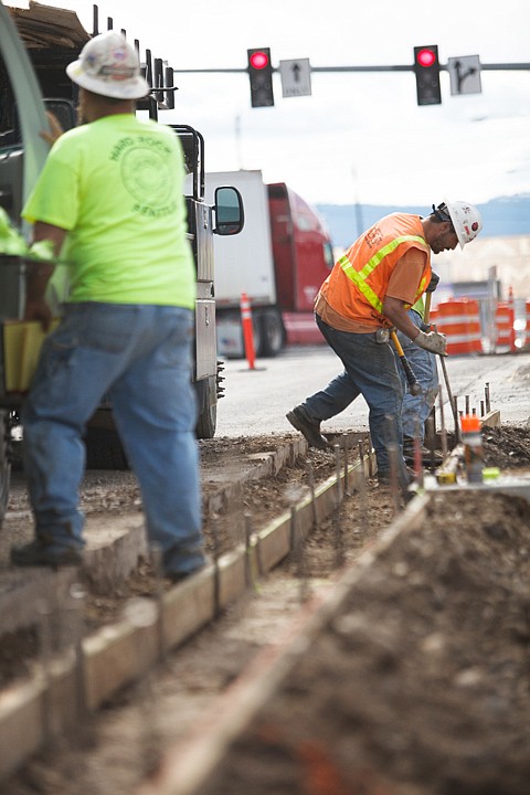 <p>Jerome Iverson, right, and Lindy Smith of WM Winkler Co. set guides to pour the concrete for the gutters on West Idaho Street in Kalispell on Tuesday afternoon. </p>