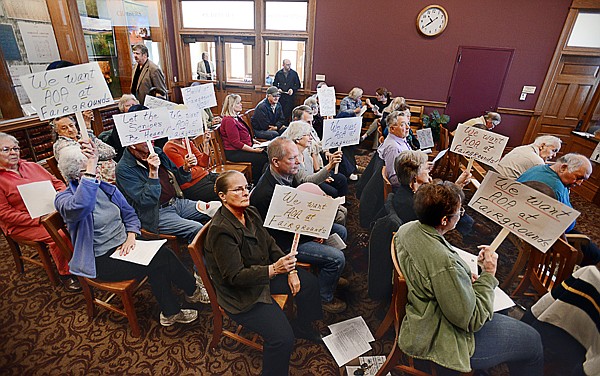 &lt;p&gt;County Commissioner Gary Krueger, top left, steps out of the commissioners meeting room filled with senior citizens holding signs that read &quot;Let the seniors be heard,&quot; and &quot;We want AOA at Fairgrounds.&quot; Krueger and Commissioner Pam Holmquist later voted to stop a grant application to help fund a new Agency on Aging building.&lt;/p&gt;