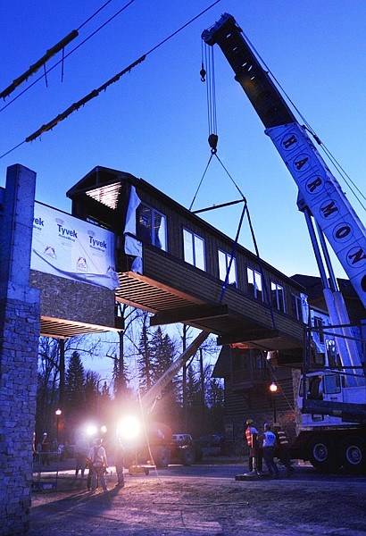 Work crews turn on lights as they align the center section of the new skybridge over Wisconsin Avenue on Wednesday night in Whitefish. Traffic was reduced to one lane and rerouted through the parking lot of the Whitefish Lake Lodge.