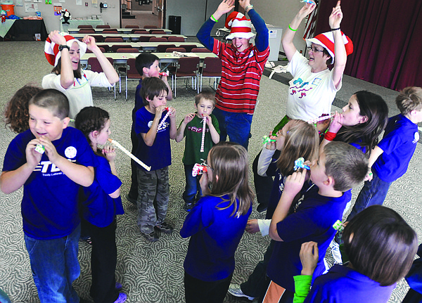 Amanda Von Trapp, of Kalispell, left to right, Thomas Klein, of Columbia Falls, and Carol Brannan of Kalispell, cheer along with students from Trinity Lutheran after they finish singing a rendition of Horton swallows a Who on Friday at the FVCC Seussville event.