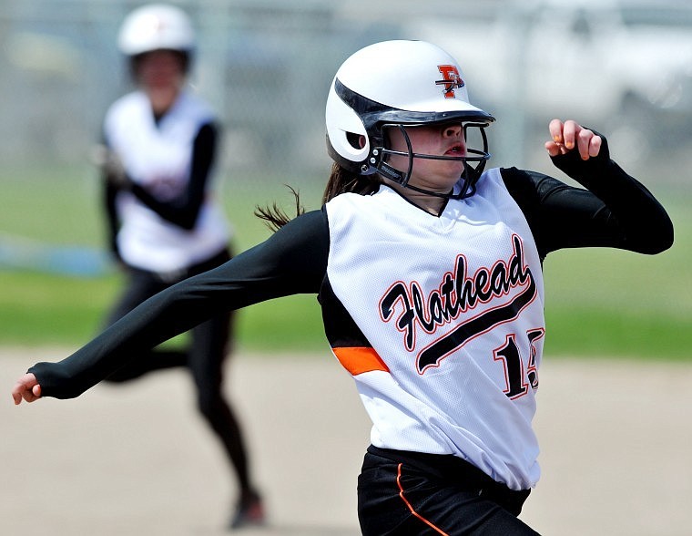 Flathead's Taylor Twichel sprints to third base despite having her helmet partially block her view of the basepath.