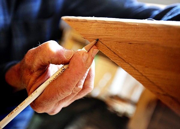 Greg Morley draws a guide line where the stem will be attached to a replica of a Kootenai canoe design  in his shop on Wednesday, April 14.