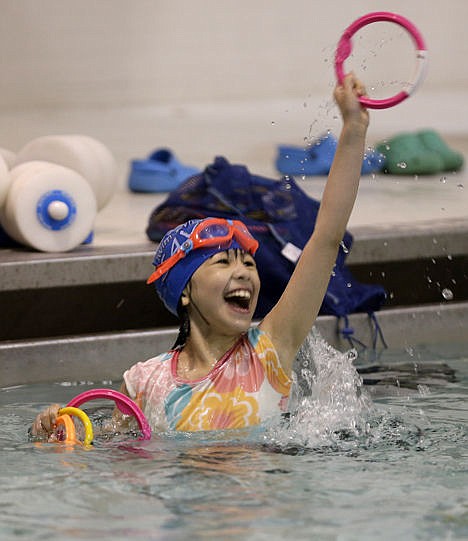 <p>Anna Shalah, 8, plays with ring toys during a swim lesson in the Bronx borough of New York, April 15.</p>