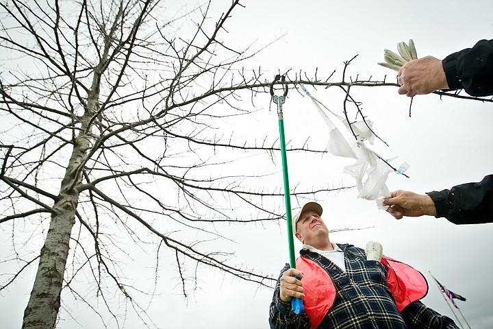 &lt;p&gt;JEROME A. POLLOS/Press Steve Peak, left, pulls down a branch so his coworker Joel Barker can remove a plastic bag stuck in a tree Thursday outside of Kimball Office in Post Falls. Employees of the manufacturing facility took Seltice Way picking up debris for Earth Day.&lt;/p&gt;