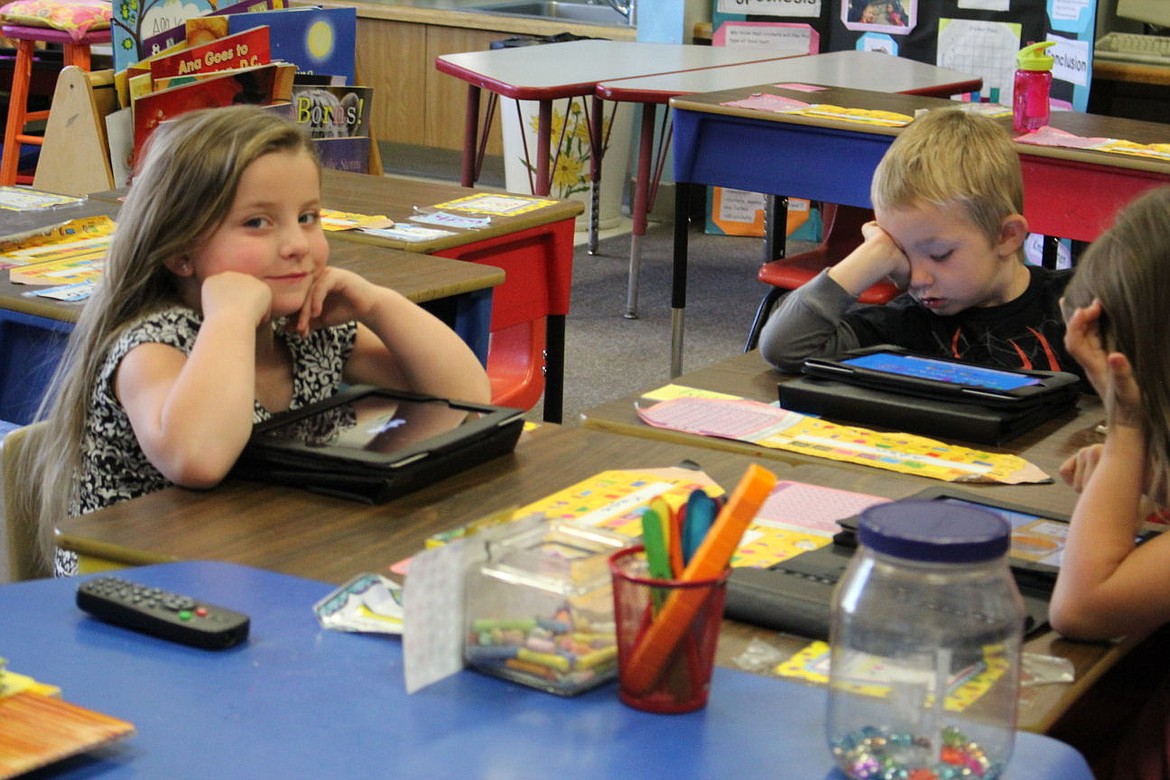 &lt;p&gt;Bella Cheesman, Tucker Desoto, and Nichole Shope, play with ipads at Kindergarten Roundup at St. Regis School on April 20.&lt;/p&gt;