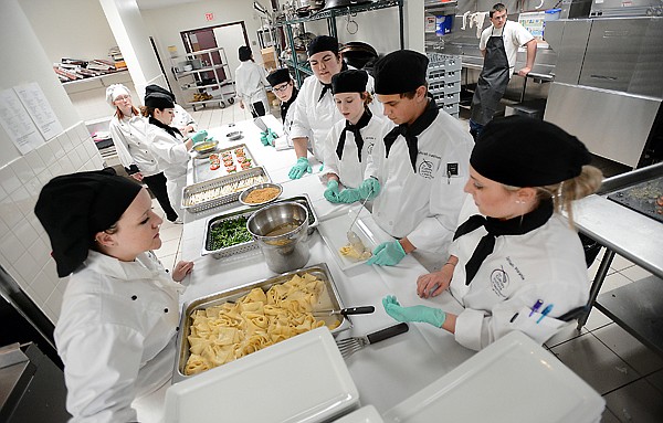<p>From left, Hallie Conlan, Michaella Irlbeck, Natasha Seiler, Jessica Strickle, Kami Wellman, Melinda Kraemer, Jacob Hausauer, and Darrian Haynie work on preparing the main course for 33 attendees at the first Chef's Table Vegetarian Night on Friday, April 19, at Flathead Valley Community College. (Brenda Ahearn/Daily Inter Lake)</p>
