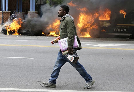 &lt;p&gt;A man carries items from a store as police vehicles burn Monday after the funeral of Freddie Gray in Baltimore. Gray died from spinal injuries about a week after he was arrested and transported in a Baltimore Police Department van.&lt;/p&gt;