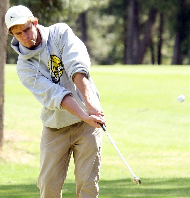 Senior Bryce Benson chips on the green at Thompson Falls course.