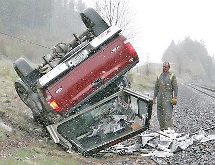 Brad Fuqua/The Western News Frank Thurow of Pioneer Auto and Wrecking watches as a tow cable begins to overturn a pickup that crashed on Highway 2 between Libby and Troy on Thursday.