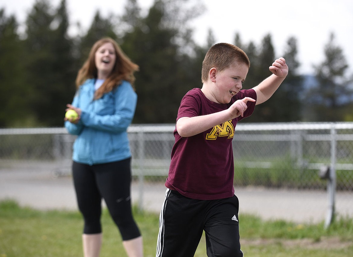<p>Brady Streitmatter celebrates after throwing a tennis ball as his coach Molly Roe cheers him on during the West Valley Warriors Special Olympic team's practice on Tuesday. (Aaric Bryan/Daily Inter Lake)</p>