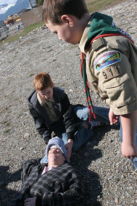 <p>Cayman Kirkhart stablizes "fall victim" Andy Lincoln's neck while Vincent Russo looks on.</p>