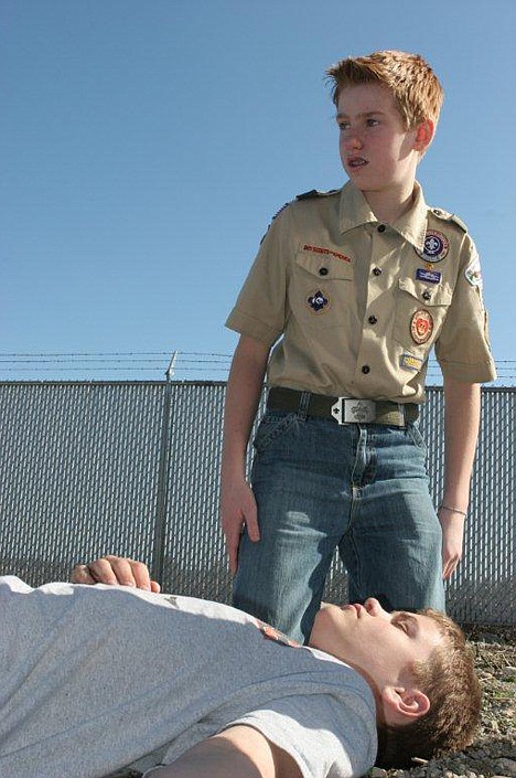 <p>Cayman Kirkhart surveys the scene while rendering aid to accident victim Collin Hildreth.</p>