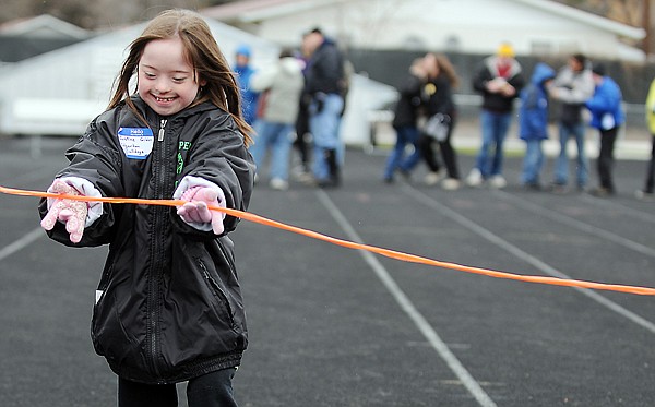 Justine Gibbs of the Edgerton Bulldogs smiles as she reaches the finish line on Friday during the Special Olympics.