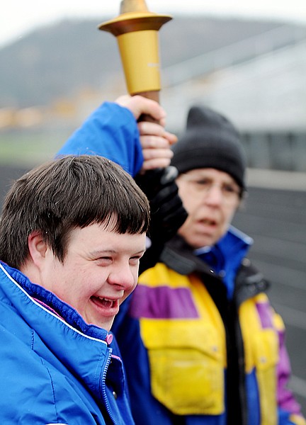 Matthew Bell and Becky West of the Krushing Boundaries team bring in the torch at the start of the Special Olympics on Friday in Kalispell.