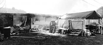 Area firefighters spray water after dousing a residence with foam. Nate Chute/Daily Inter Lake