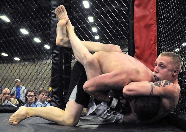 Phillip McClendon is pressed up against the fence by Kent Johnson.