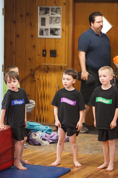 <p>Patrick Cote/Daily Inter Lake With their father Bret in the background, the three boys of the Stanislao quadruplets wait for gymnastics class to start Thursday afternoon. The six-year-old quadruplets wear shirts with their names printed on the front to help people remember who is who. Thursday, April 19, 2012 in Bigfork, Montana.</p>