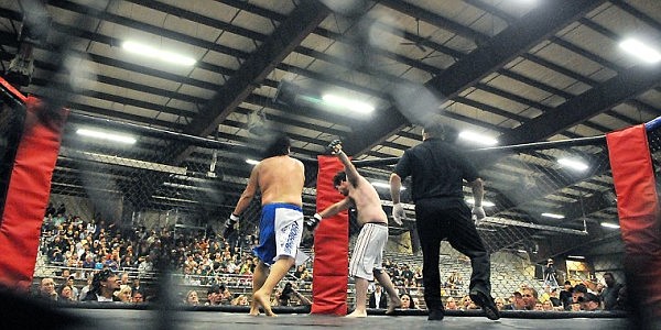 Jason Mustin falls back toward the fence after getting hit by Alonzo Bringsyellow.