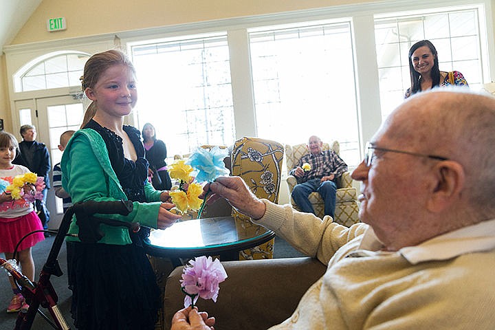 &lt;p&gt;Lexi Gorton, a first-grade student at Genesis Preparatory Academy, hands a flower to Lyal Martin, 92, a resident of The Renaissance at Coeur d'Alene assisted living facility, as part of May Day celebrations. About 25 students handed out flowers, made of tissue paper, to the residents and also sang songs during their visit on Thursday.&lt;/p&gt;