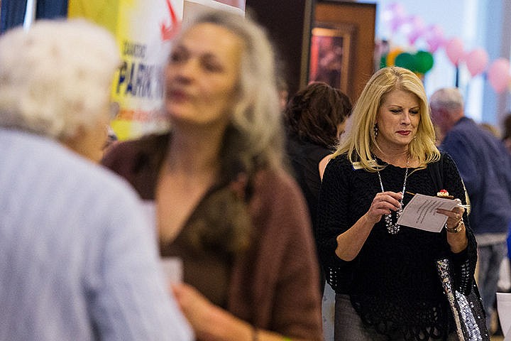 &lt;p&gt;Carole Robinson, branch director for Homewatch Caregivers, reads information while browsing the many booths at the Post Falls Chamber of Commerce Community Business Fair Wednesday at the Greyhound Park and Event Center in Post Falls. Dozens of local business offered information, prizes and free items to promote their companies.&lt;/p&gt;