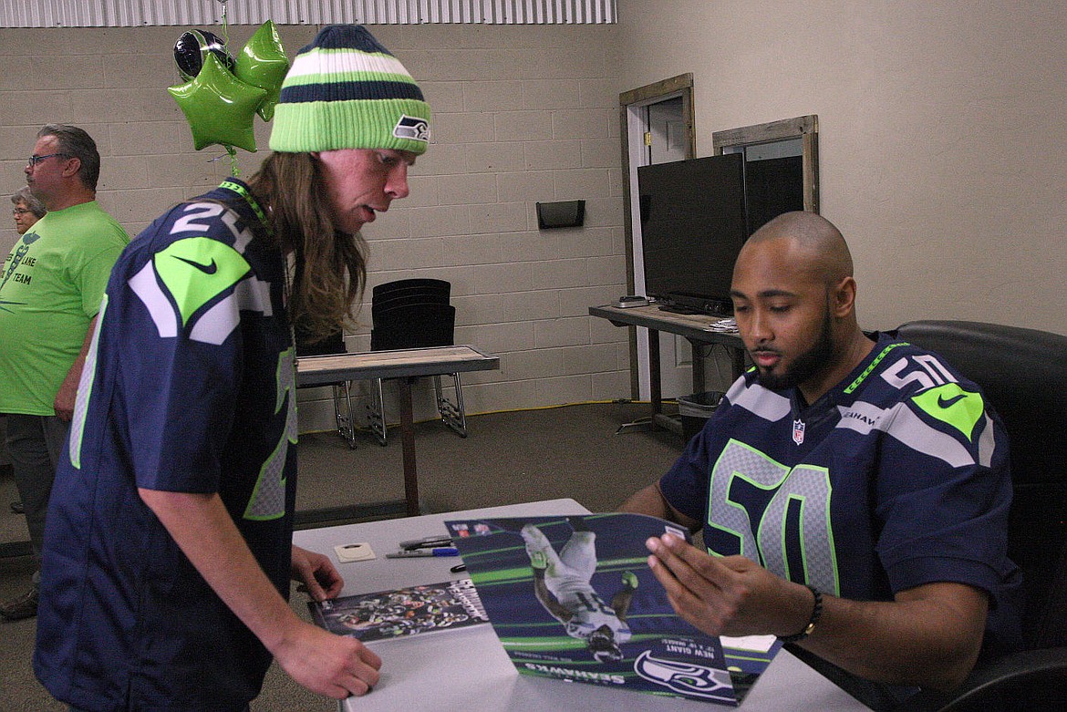 Rodney Harwood/Columbia Basin Herald Anthony Brown of Moses Lake get an autograph from Seahawks linebacker K. J. Wright. Write was in Moses Lake on Saturday to help raise money for the Moses Lake Medical Team.