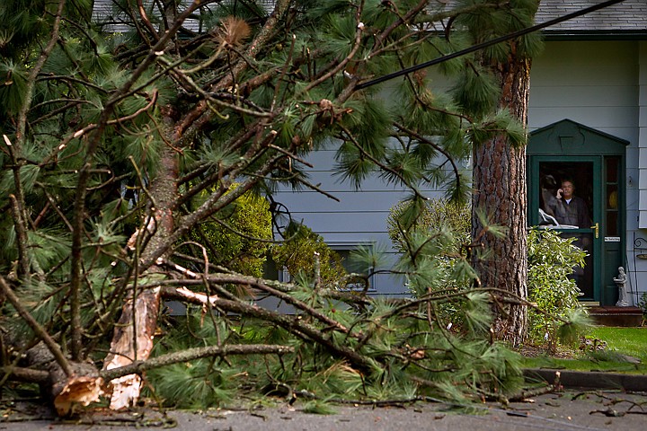 &lt;p&gt;Tim Morning watches from his front door as firefighters secure an area around his home on Fairway Drive in Coeur d'Alene after the top of two pine trees snapped and fell onto power lines.&lt;/p&gt;