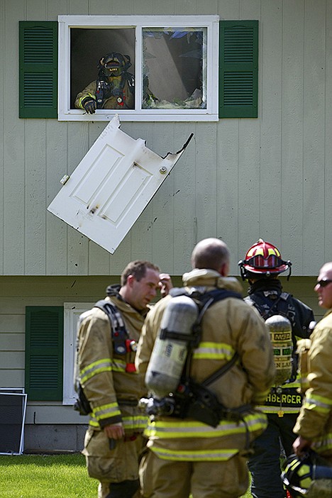 &lt;p&gt;A Kootenai County firefighter drops a interior door that was damaged by a house fire Friday on the 1300-block of Fernwood Court in Coeur d'Alene.&lt;/p&gt;