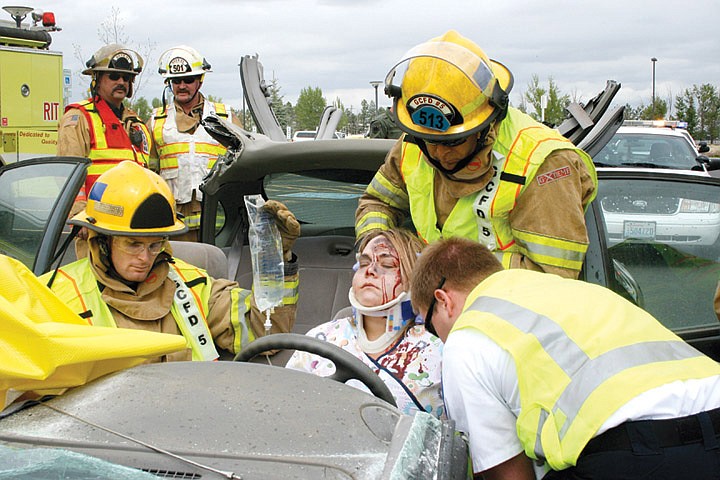 Firefighters and EMTs surround Crystal Mertes, Moses Lake, one of four 'victims' in a mock car crash staged during the Community Partnership Against Substance Abuse May 3.