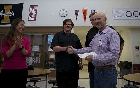 &lt;p&gt;Greta Gissel applauds as Venture High School sophomore Chastin Raper presents a $200 donation to Coeur d'Alene School District Trustee Dave Eubanks on Monday. Raper worked with students like Bryce Hayes (pictured in background) to make coffee to sell to classmates and staff at the school and donated all of the proceeds to the district's Jingle Books Program.&#160;&lt;/p&gt;