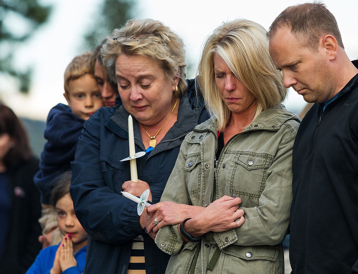 &lt;p&gt;Linda Blumer, far left, Ashley Ford and her husband Luke embrace during an emotional gathering following the death of Sgt. Greg Moore, with the Coeur d&#146;Alene Police Department Tuesday, May 5, 2015 at Candlelight Christian Fellowship. Nearly 400 attended the candlelight vigil as a show of support.&lt;/p&gt;