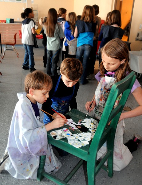 <p>From left, Quinten Calbick, Bodie Fosberg, and Becky Saari, third graders at Bigfork Elementary paint a chair which will be part of an art auction for fifth grader Ember Fortuna who was diagnosed with lymphoma. The Art Show and Silent Auction will be held on Friday, May 11, at the Bigfork Elementary Cafeteria from 5 to 8 p.m.</p>