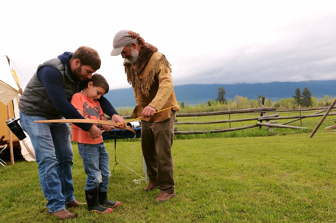 &lt;p&gt;Elliott Natz/Lake County Leader Chase Jordan tries to notch an arrow with the help of his father, Travis, and Gary Steele, right. Jordan was practicing his archery skills at Steele's exhibit where he had axe throwing, an atlatl, and bow and arrows.&lt;/p&gt;