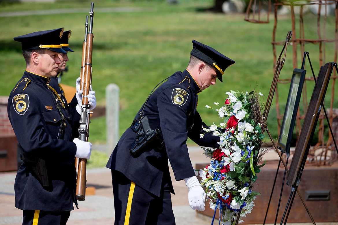 &lt;p&gt;Members of the Coeur d'Alene Police Honor Guard lay a wreath of flowers in front of picutes of Sgt. Greg Moore on Thursday at a memorial service for the fallen officer.&lt;/p&gt;