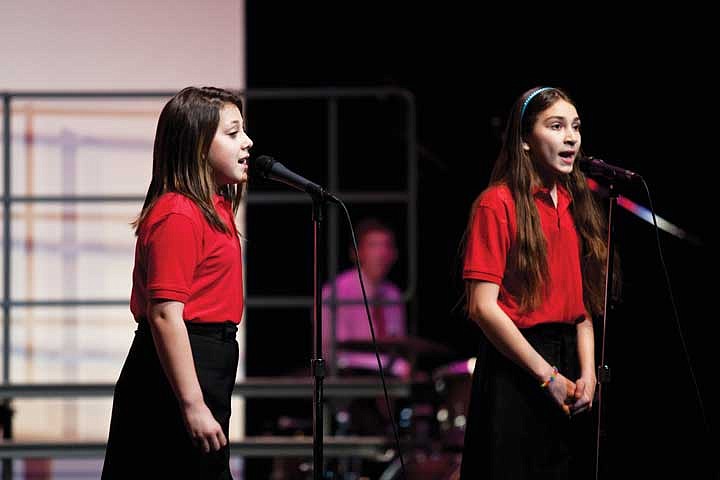 Chloe Padilla and Isabella Flores sing during the &#147;Voices of a New Day&#148; March concert. The choir is celebrating its 10-year anniversary this year.