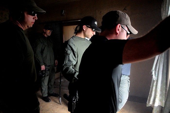 <p>Jordan Venezio, center, and members of the Police Department SRT and Sheriff's Department SWAT teams gather to examine the set up of a window breaching exercise on Monday, April 23, in Kalispell.</p>