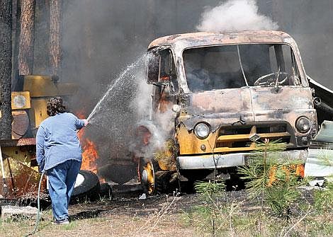 Photo by Mark McDaniel Marla Freeman did what she could to slow a blaze, which started somewhere in her backyard on Riverbend Road Monday afternoon