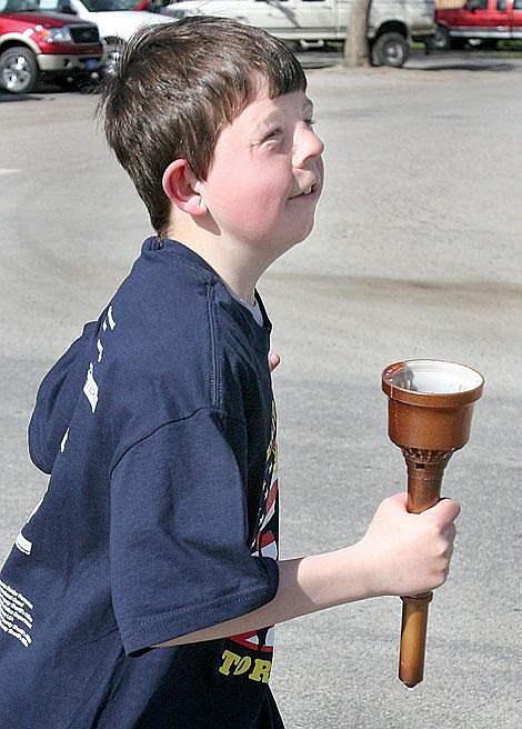 Photo by Ed Moreth Twelve-year-old Riley Montgomery takes the torch on the final leg of the run.