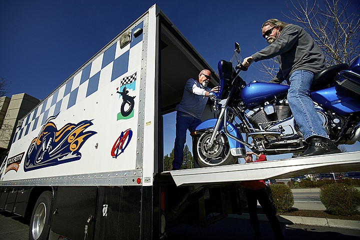 &lt;p&gt;JEROME A. POLLOS/Press Terry Campbell stabilizes a Harley Davidson motorcycle on a ramp as Mo Irvin helps roll the motorcycle out of a truck Wednesday as the board members of the Kyle Petty Charity Ride prepare for a trip Saturday to Boise from Coeur d'Alene. The charity ride raises funds for charities that support chronically ill children. Since 1995, more than 7,180 riders have logged 10.4 million cumulative motorcycle miles and donated nearly $15 million.&lt;/p&gt;