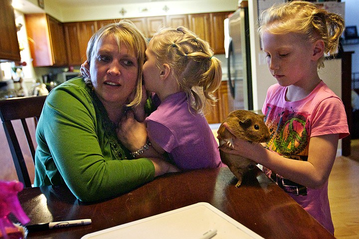 &lt;p&gt;Cindy Barnett listens to her daughter Josie, 7, tell her a secret while her twin daughter Mariah plays with her pet guinea pig Friday at their home in Post Falls.&lt;/p&gt;