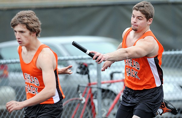 Flathead's Jeremy Grosswieler hands the baton to Michael Managhan during the varsity boys 4x100 relay at the Archie Roe Track Meet in Kalispell.