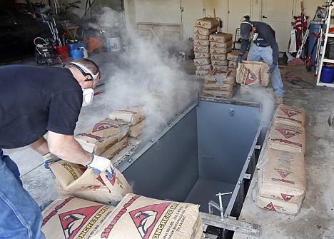 &lt;p&gt;Jim Hohnsbehn, left, and Jacob Ortiz, of Thunderground Storm Shelters, pour bags of concrete around the sides of a storm shelter during an installation into the garage of a residence in Oklahoma City, May 1.&lt;/p&gt;