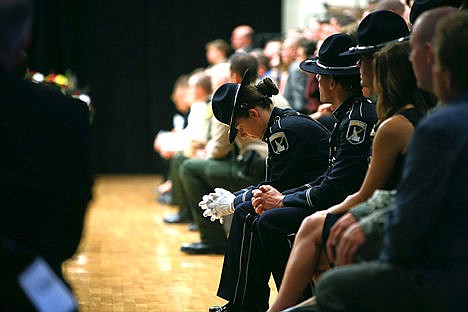 &lt;p&gt;An Idaho State Trooper looks to her hands during the first speech given by Pastor Rodney Wright. Law enforcement from places such as Montana, Washington, and Canada attended the funeral.&lt;/p&gt;