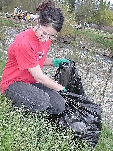 Libby High School sophomore Shayla Shaw picks up trash along the creek near Rosauers.